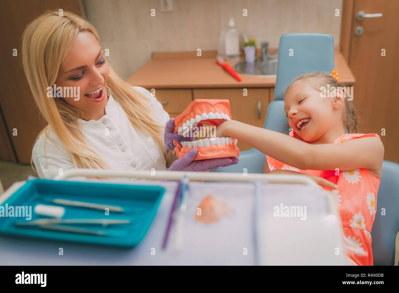 Beautiful Little Girl At Visit In The Dentist Office She And Female Dentist Having Fun With Big Teeth Stock Photo Alamy