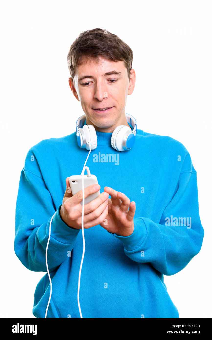 Studio shot of man wearing headphones around neck while using mo Stock Photo