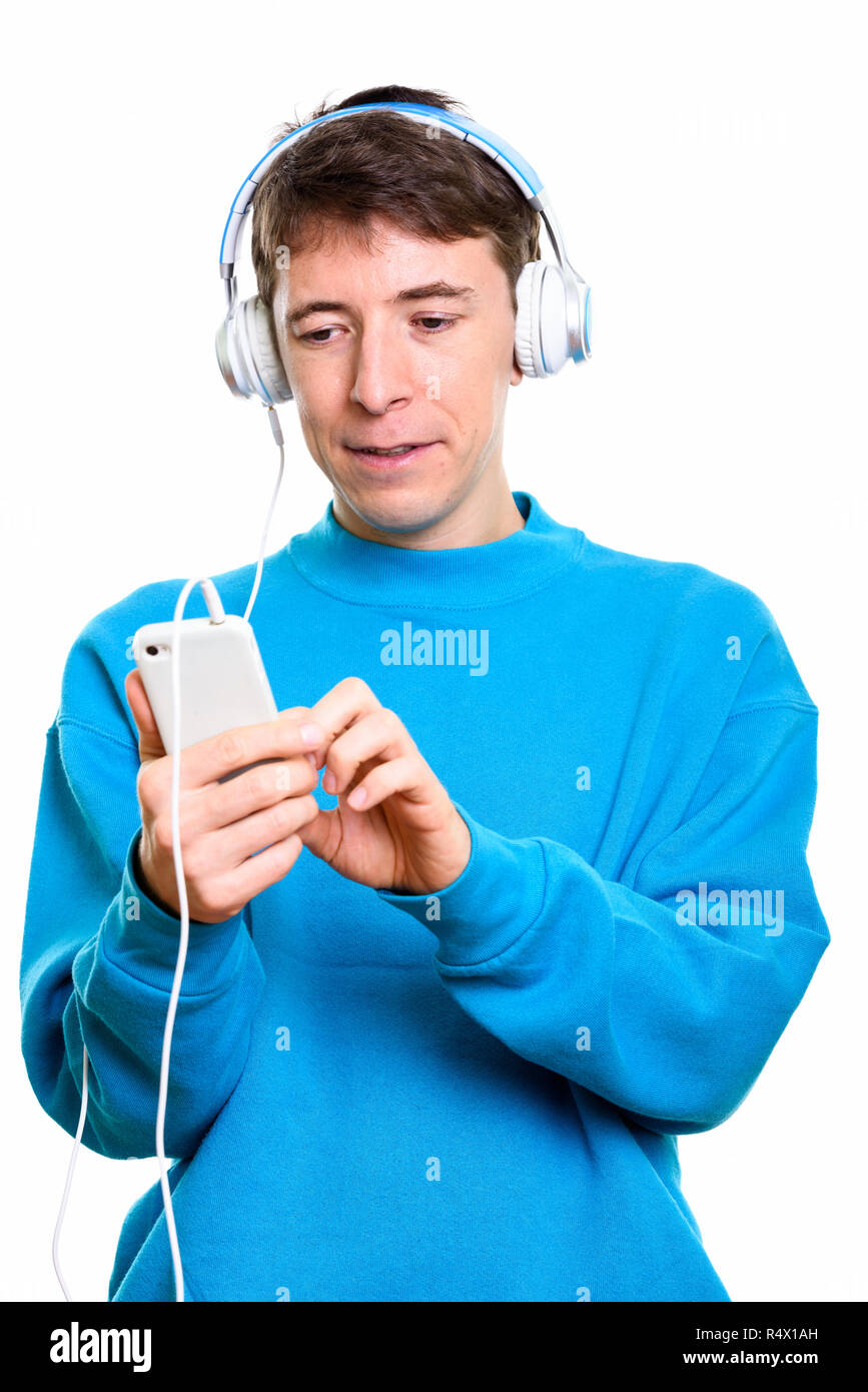 Studio shot of man listening to music while using mobile phone Stock Photo