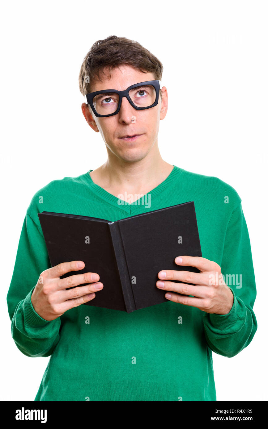 Studio shot of man holding book while thinking Stock Photo
