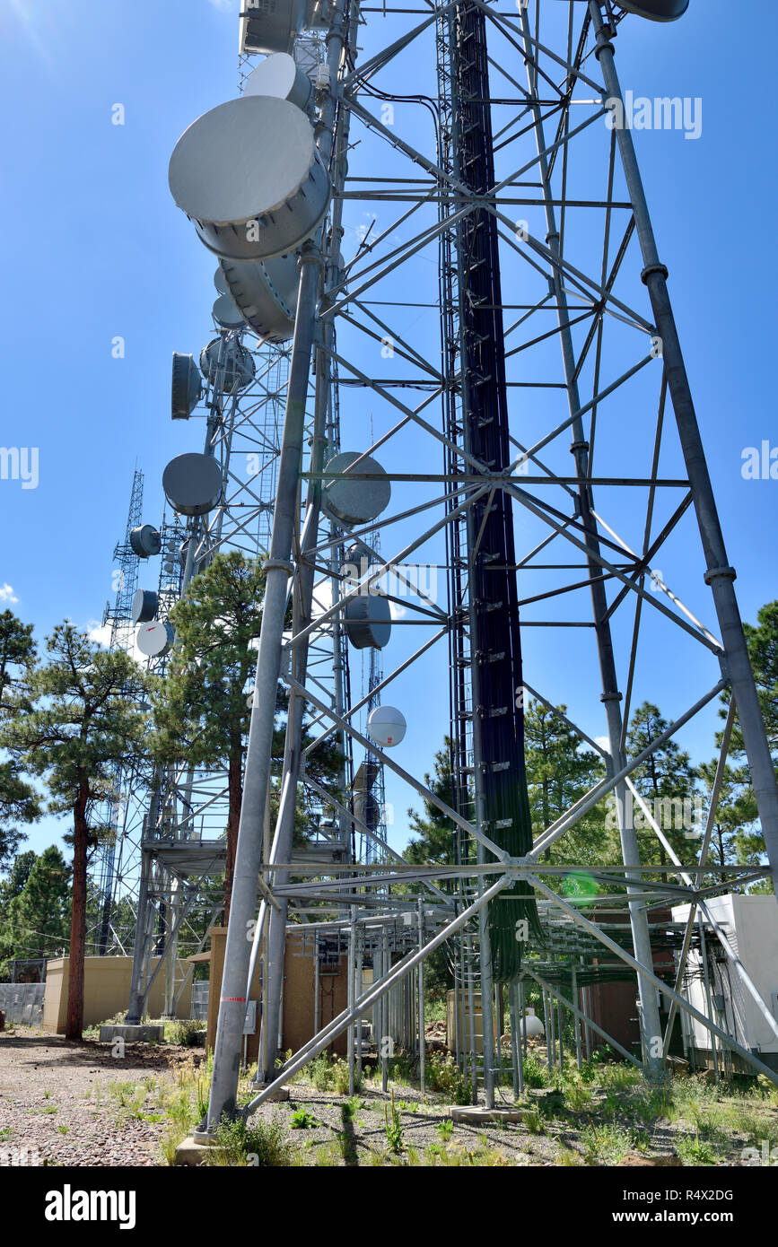 Communication towers with microwave and cell phone aerials Stock Photo