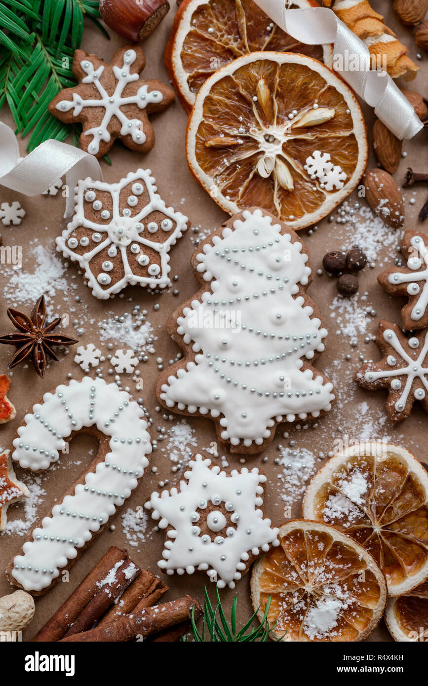 Christmas dekoration with spices and cookies in the shape of snowflakes on dark brown paper background. Top view. Stock Photo