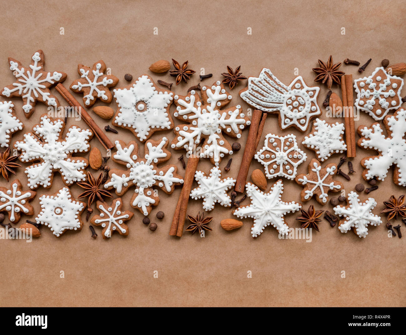 Christmas dekoration with spices and cookies in the shape of snowflakes on dark brown paper background. Top view. Stock Photo