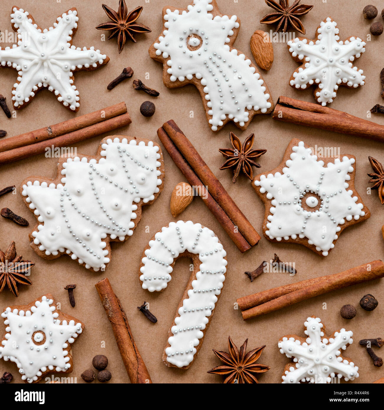 Christmas dekoration with spices and cookies in the shape of snowflakes on dark brown paper background. Top view. Stock Photo