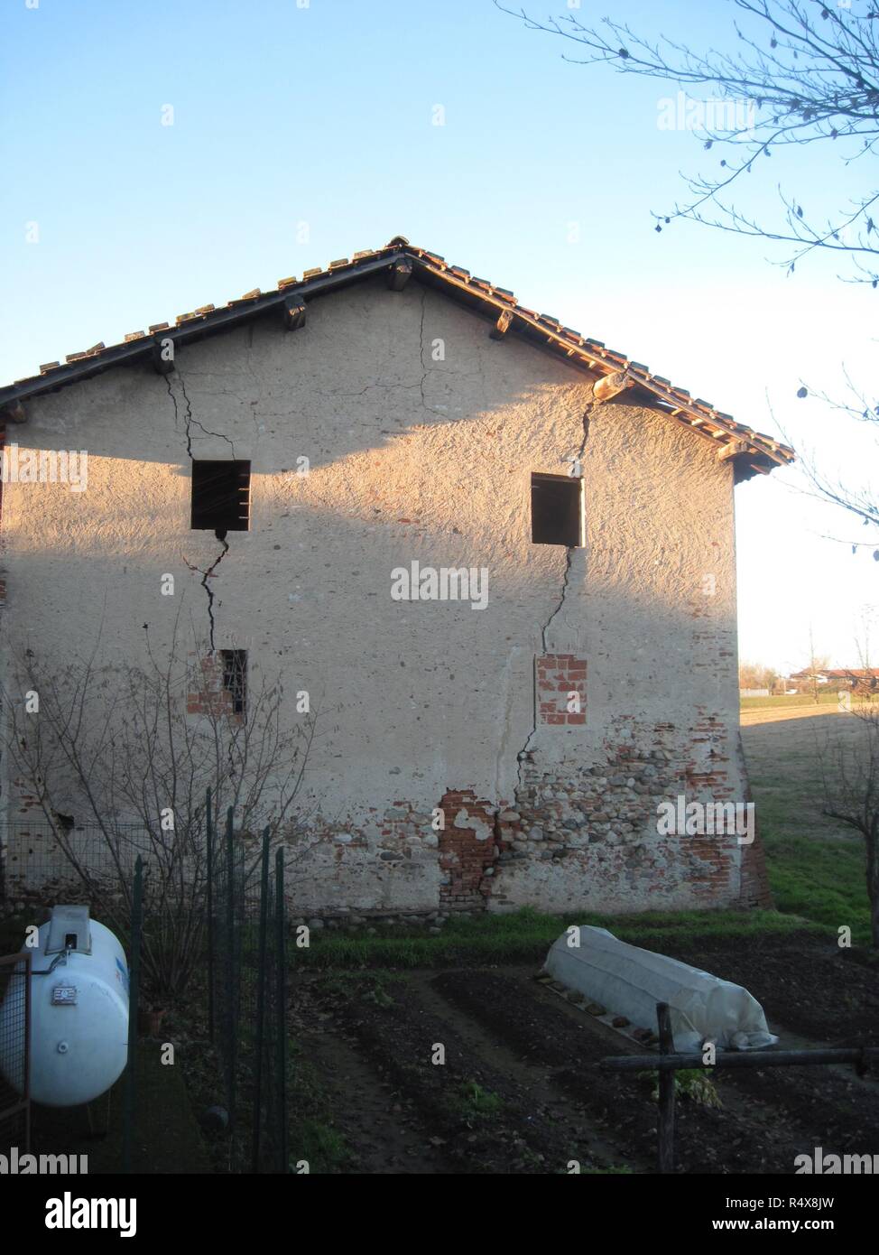 A typical Italian farmstead with wall cracks and a vegetable garden in the small rural Badia di Dulzago Dulzago hamlet, in Bellinzago, Piedmon, Italy Stock Photo