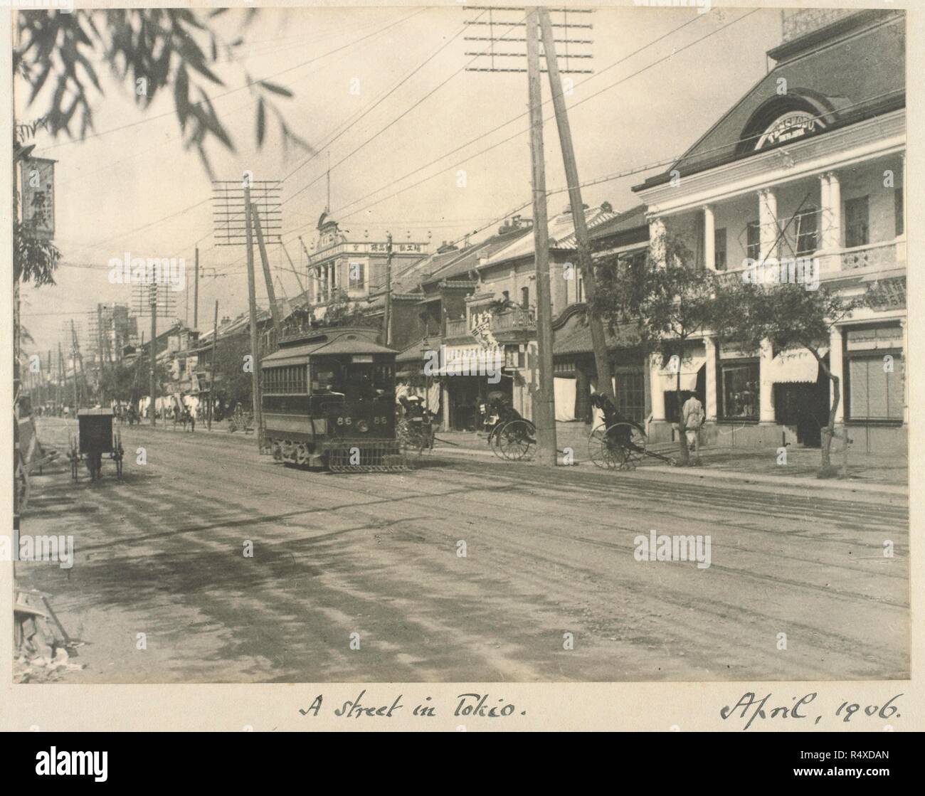 A photograph of a nineteenth-century Tokyo street. Street scene with an electric tram. Zetland Collection: Album of views of ... Japan and .... Apr-06. Source: Photo 364/7(9). Language: English. Author: Zetland, 2nd Marquess of. Abbott, William. Stock Photo