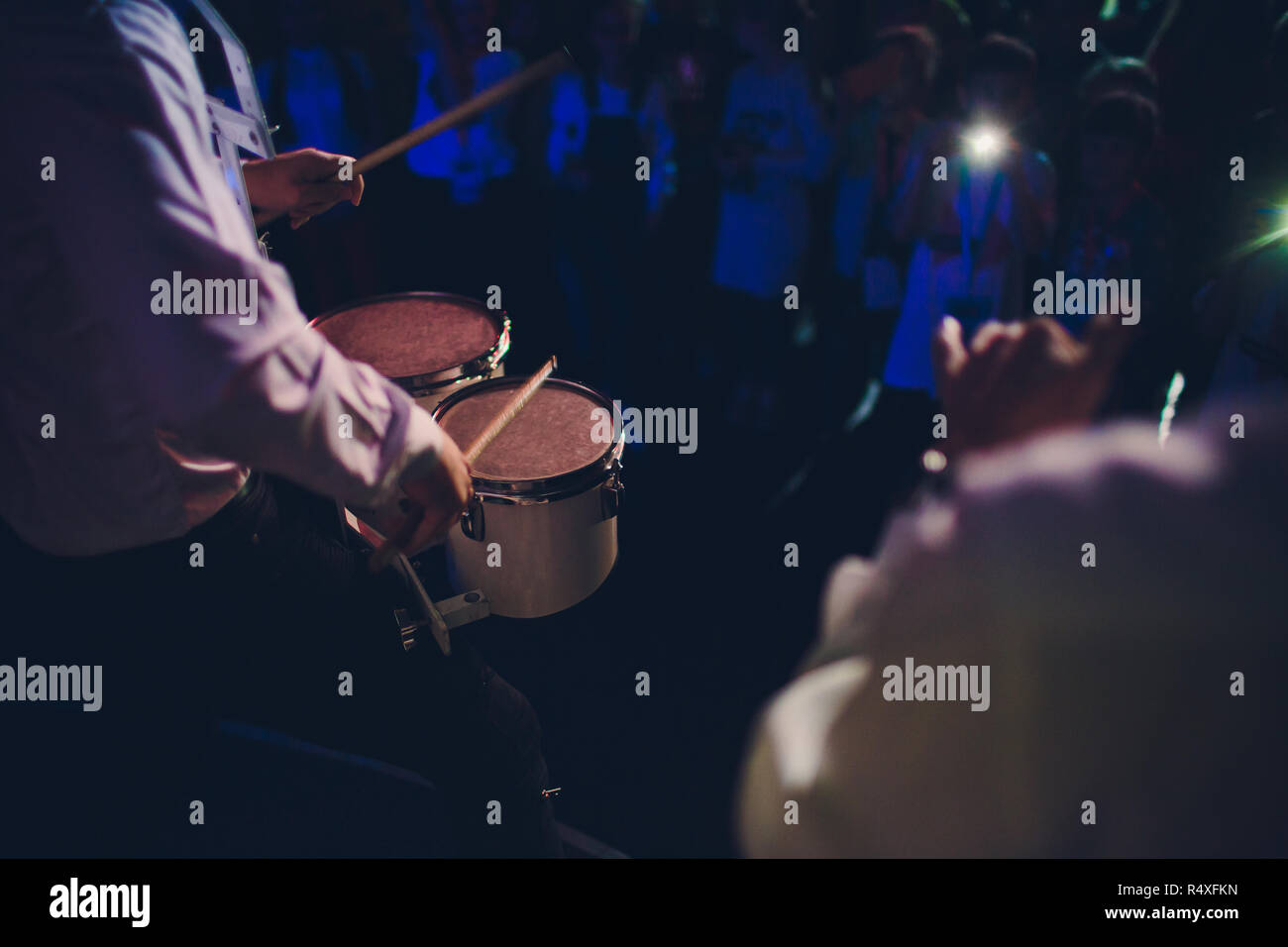 Drummer.The guy holding the drumsticks in his hand.Young man with