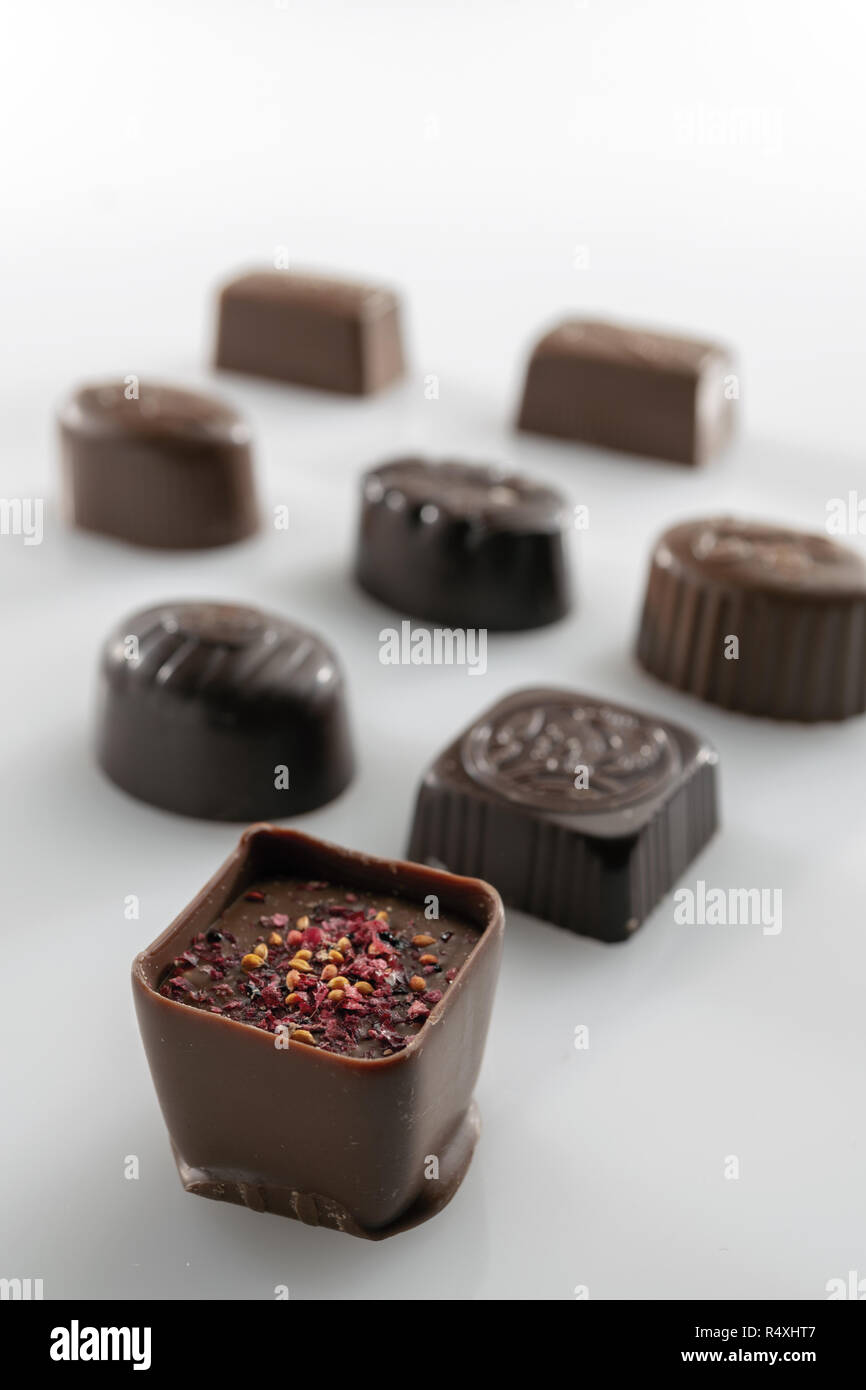 Stuffed chocolates plus flavors in front of white background with blur