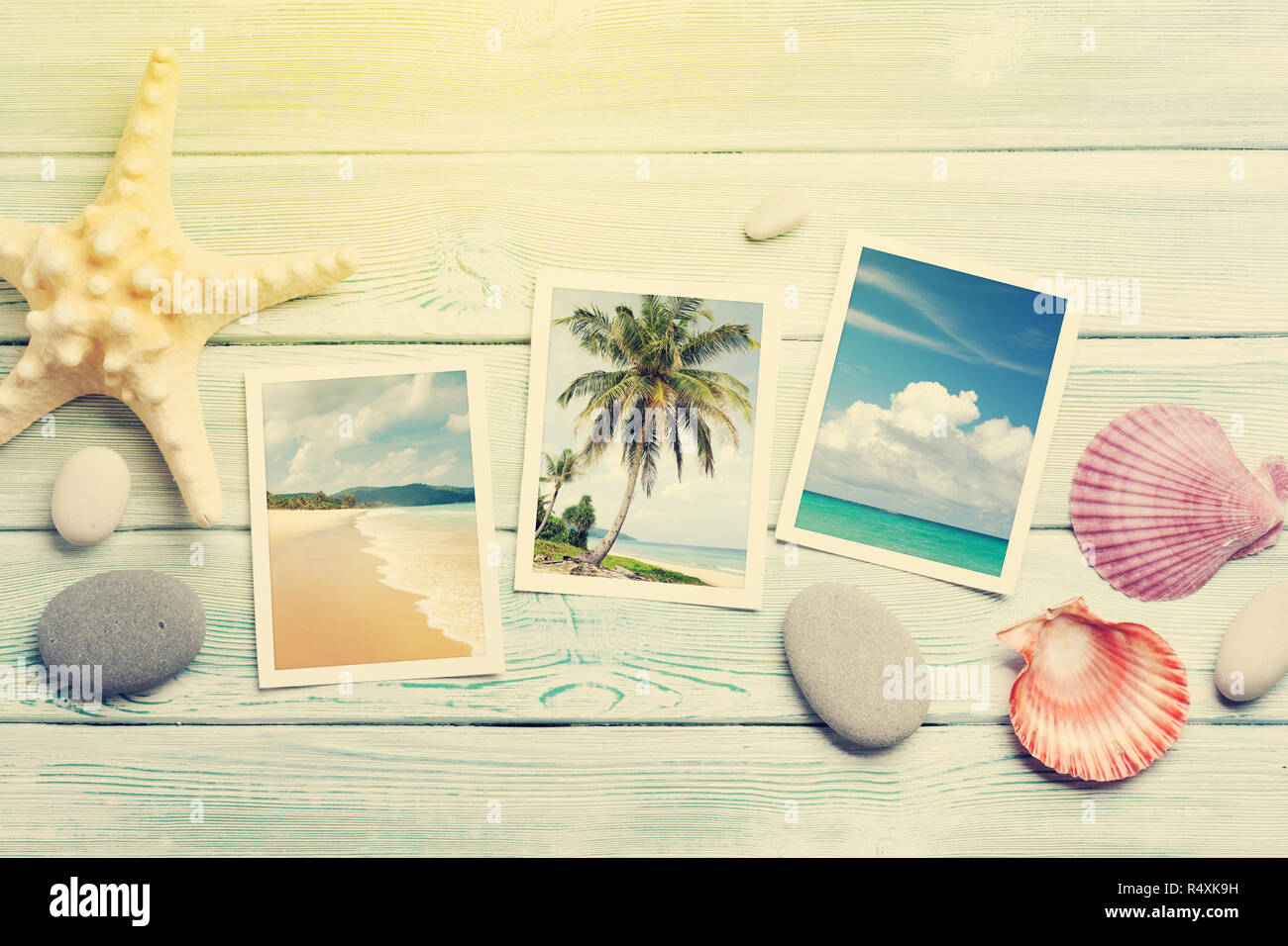 Travel vacation table concept with seashells and summer photos on wooden table. Top view. Flat lay. Photos taken by me. Sunny toned Stock Photo