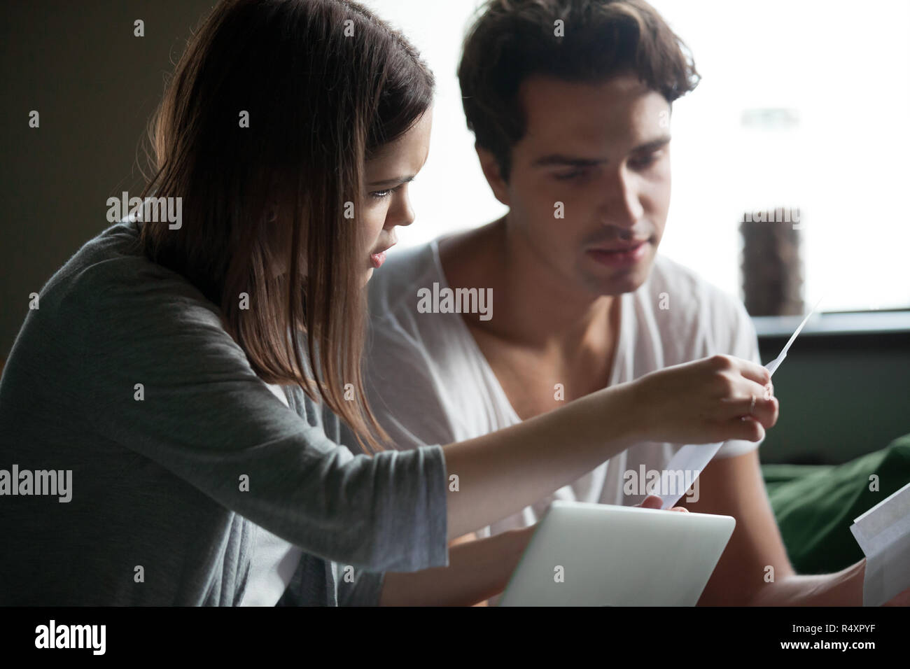 Stressed young couple checking bills at home Stock Photo