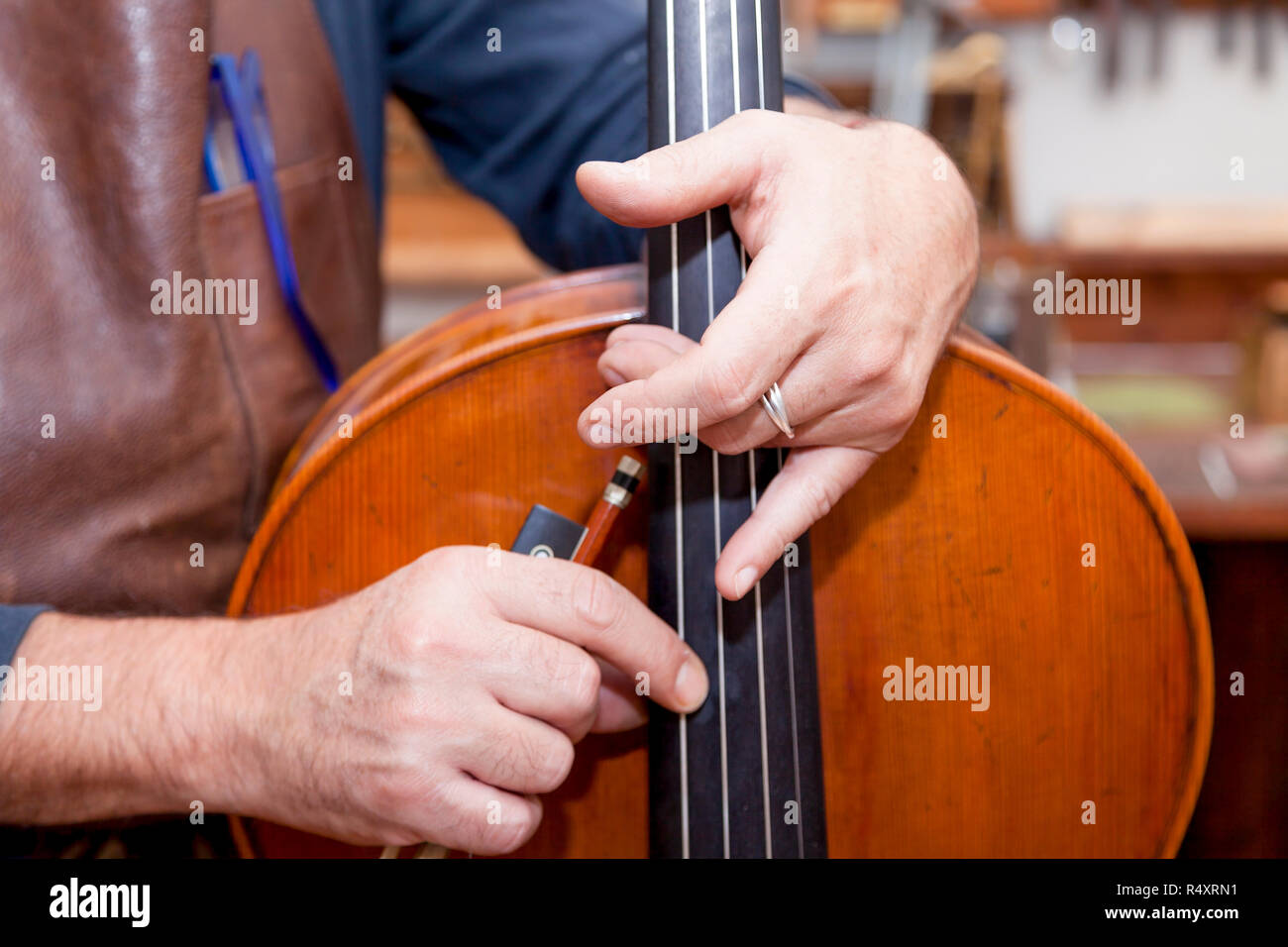 portrait of mature violin maker while testing the violins in his