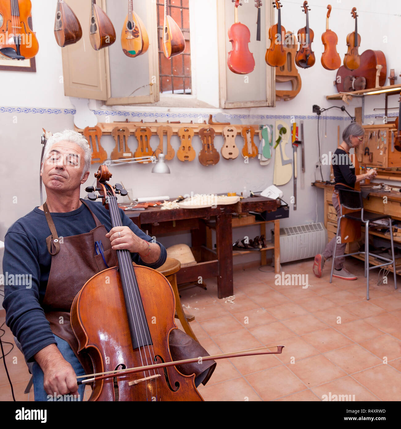 portrait of mature violin maker while testing the violins in his