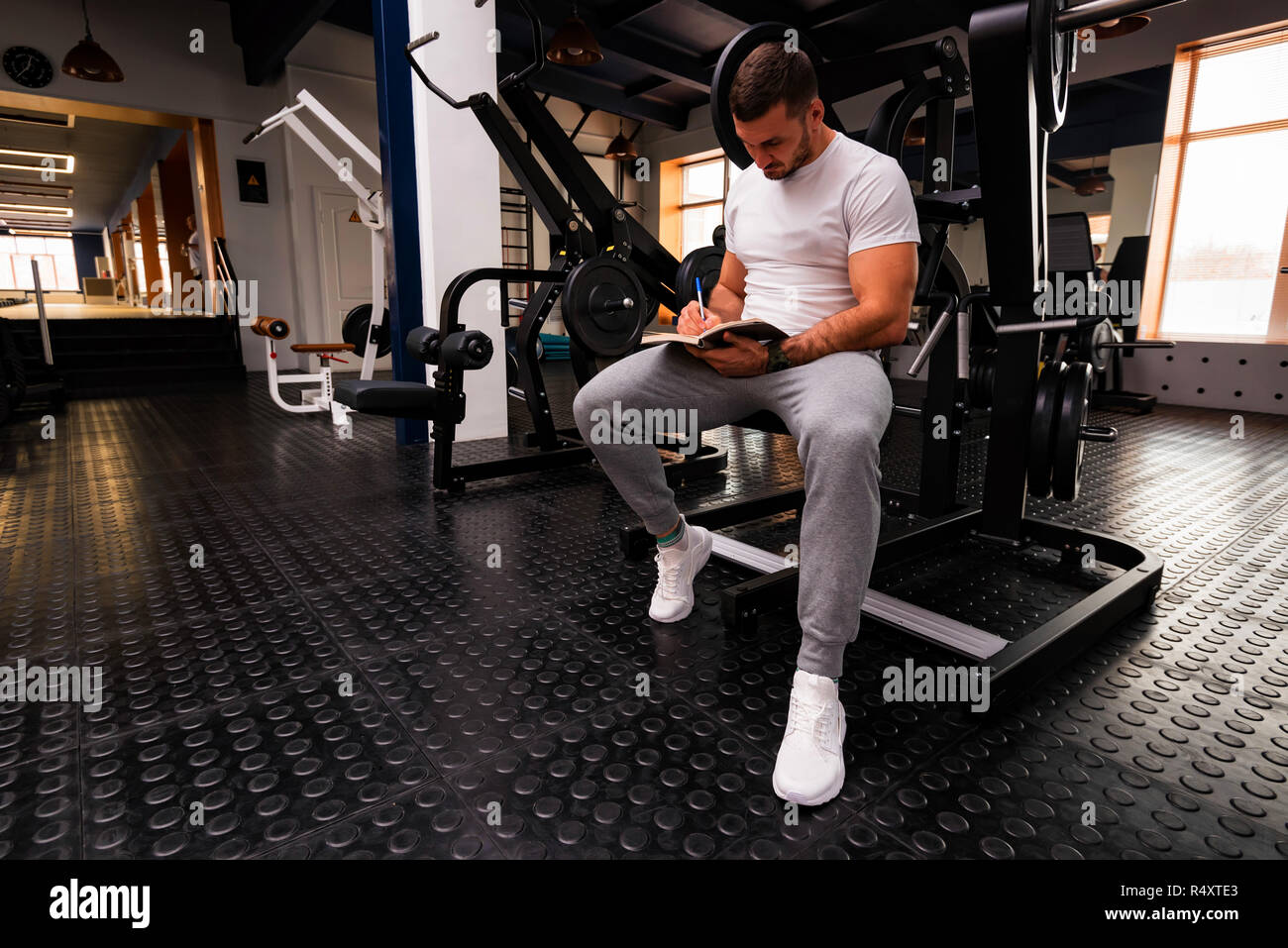 Fitness trainer writes workout plan close up in gym Stock Photo