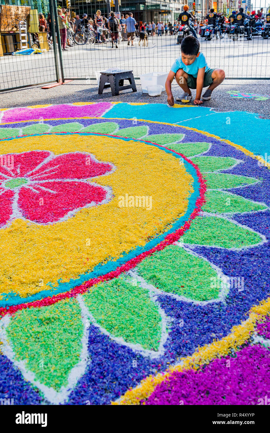 Traditional Rangoli floor mandal decoration made from coloured rice, India Live Street Festival and Celebration, Granville St. Vancouver, British Colu Stock Photo