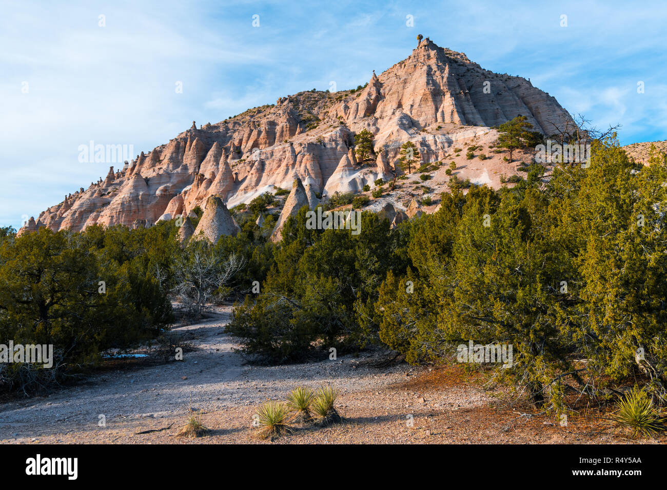 Colorful red rock peak with numerous hoodoo rock formations in evening light at Kasha-Katuwe Tent Rocks National Monument near Santa Fe, New Mexico Stock Photo