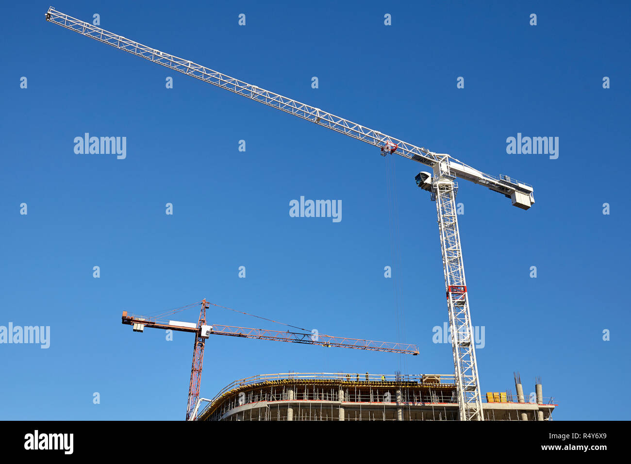 Construction site cranes against the blue sky. Stock Photo