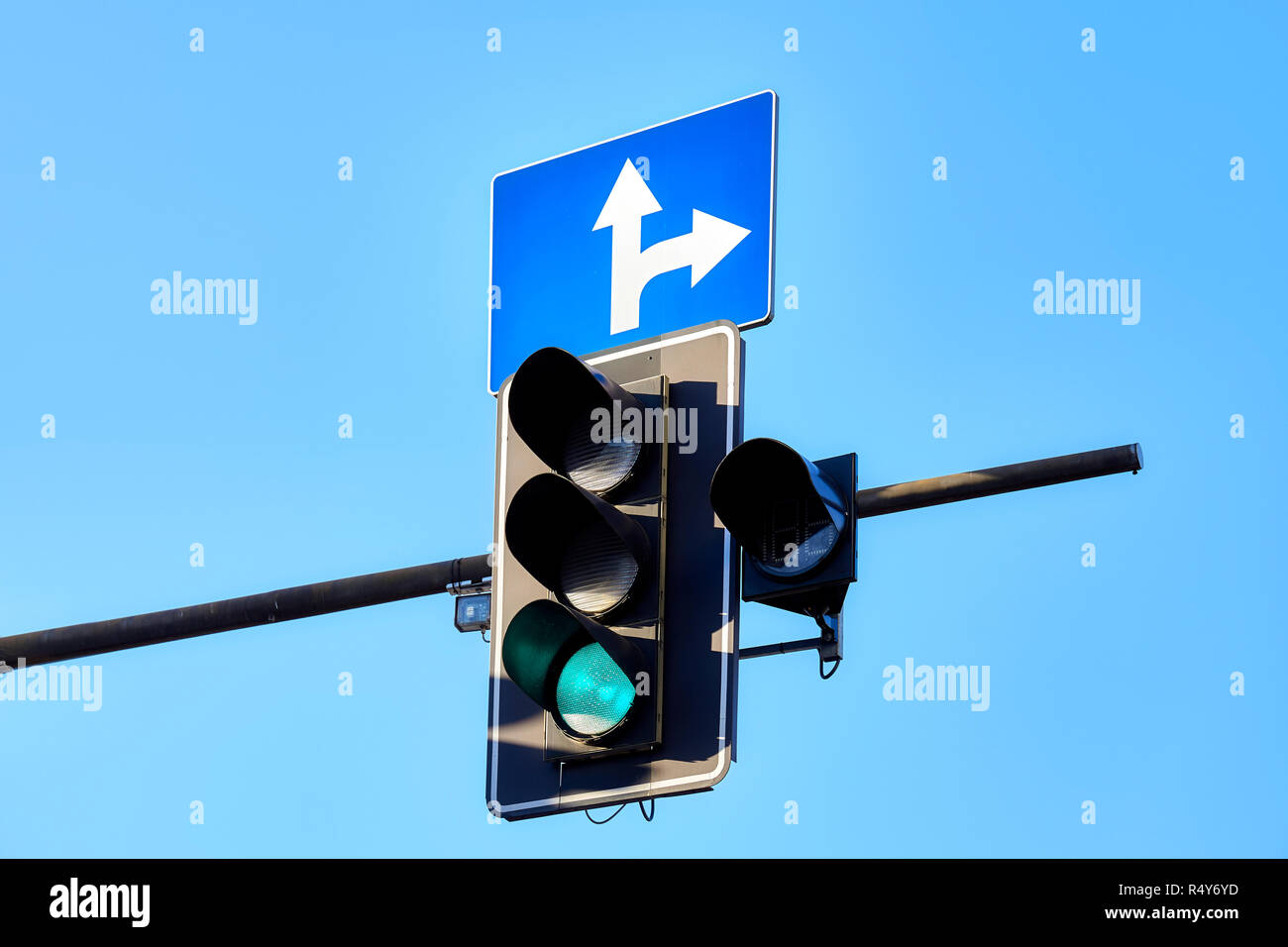 Traffic light against the blue sky, green color displayed. Stock Photo