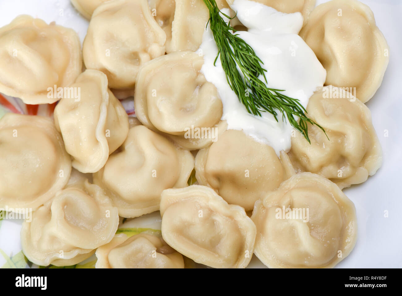 Hot dumplings with sour cream and dill. Traditional Russian dish Stock Photo