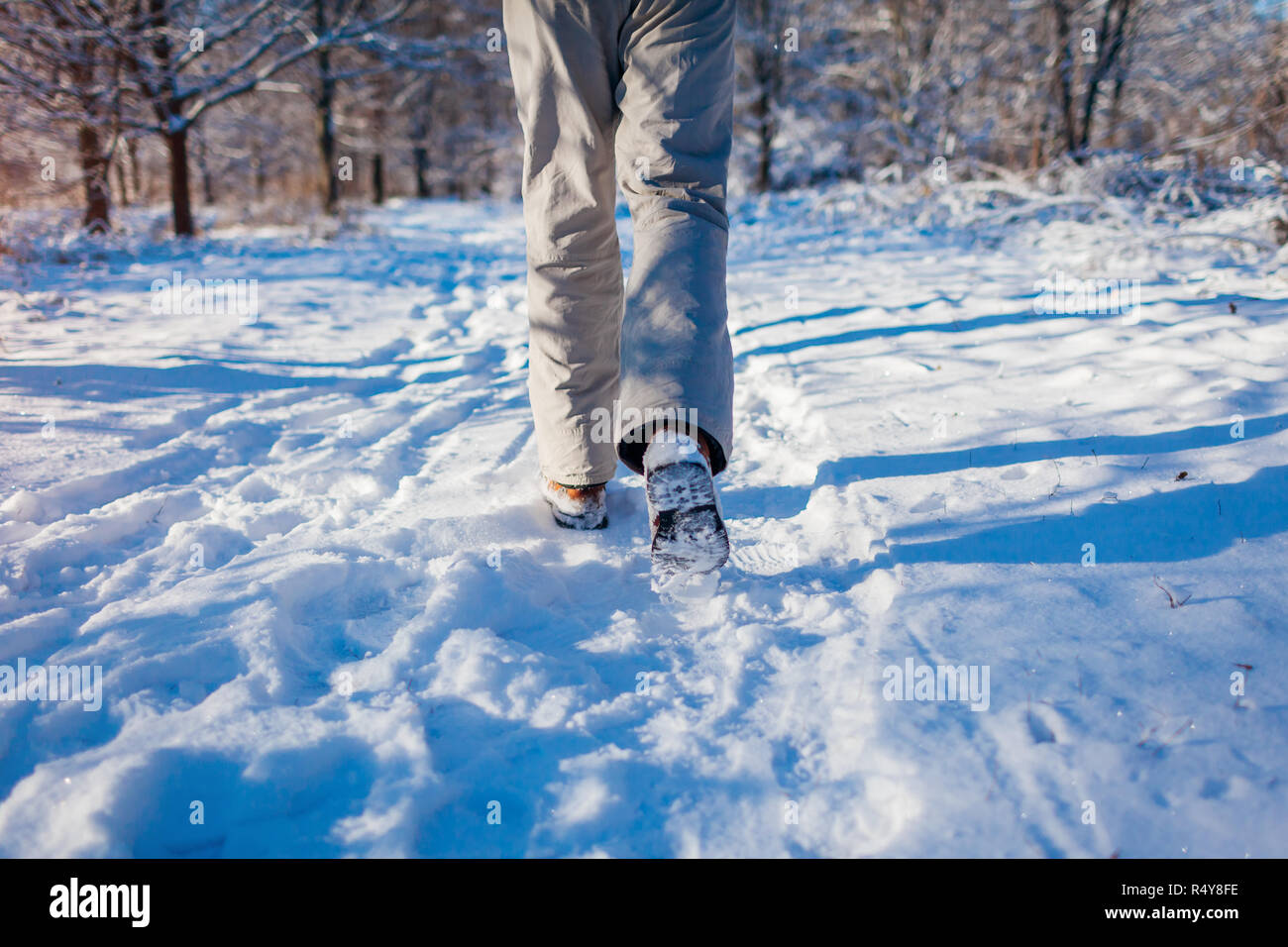 Running athlete man sprinting in winter forest. Training outside in cold snowy weather. Active healthy lifestyle. Closeup of shoes Stock Photo