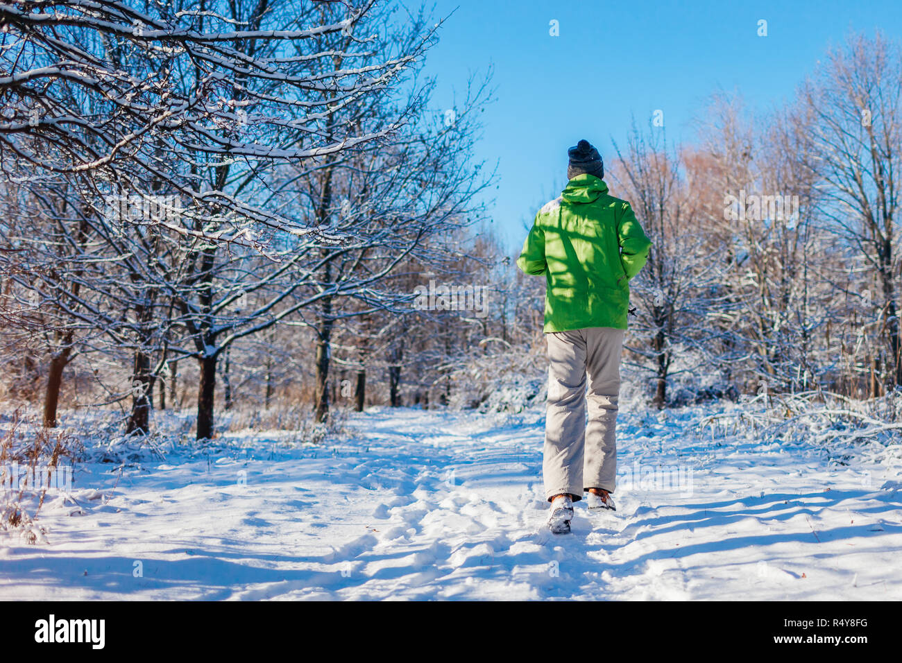 Running athlete man sprinting in winter forest. Training outside in cold snowy weather. Active healthy lifestyle Stock Photo