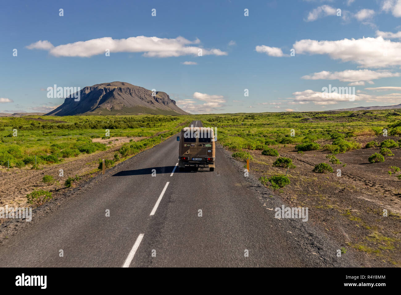A camper van travelling down a typical road in Iceland showing the ...