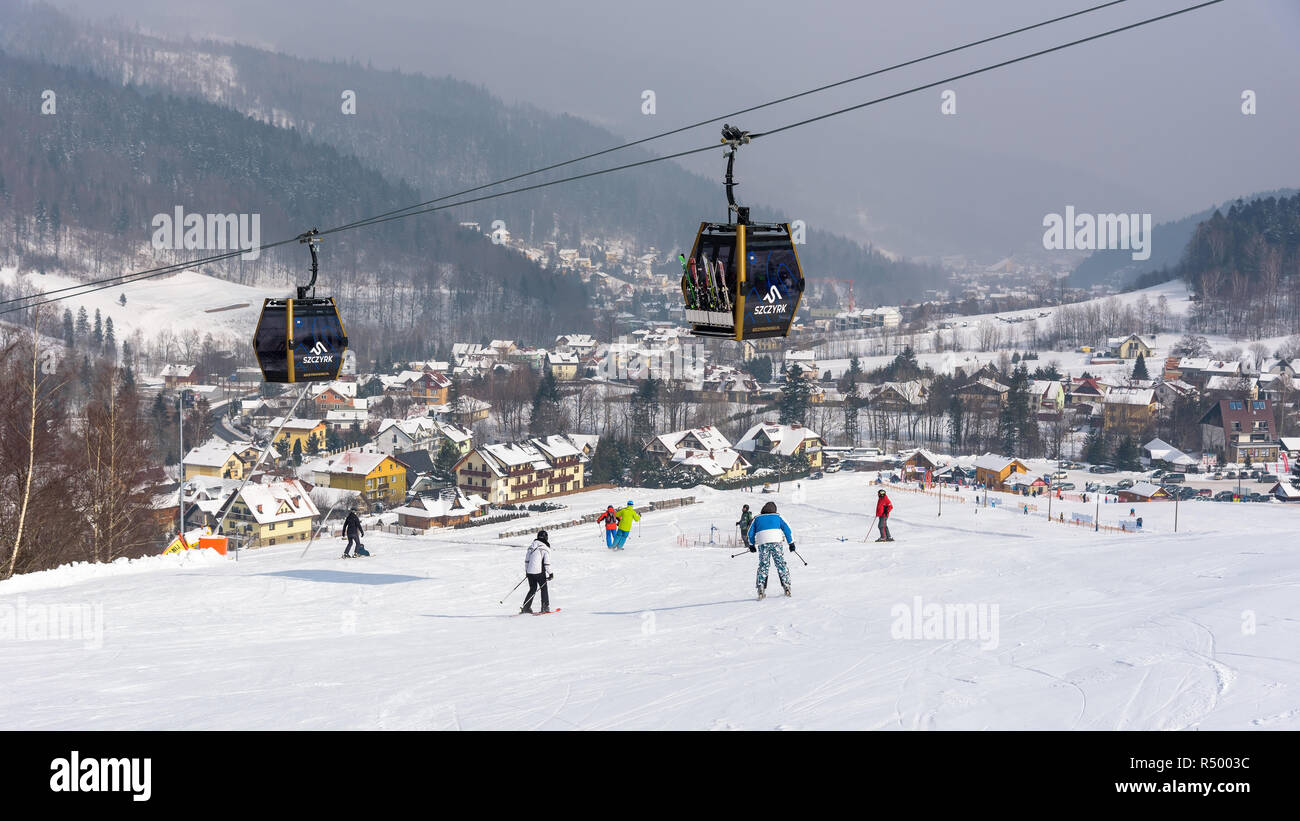 Szczyrk, Poland - February 26, 2018: People skiing at Szczyrk Mountain Resort, with a new 10-seat gondola lift and artificially snow-covered and illum Stock Photo