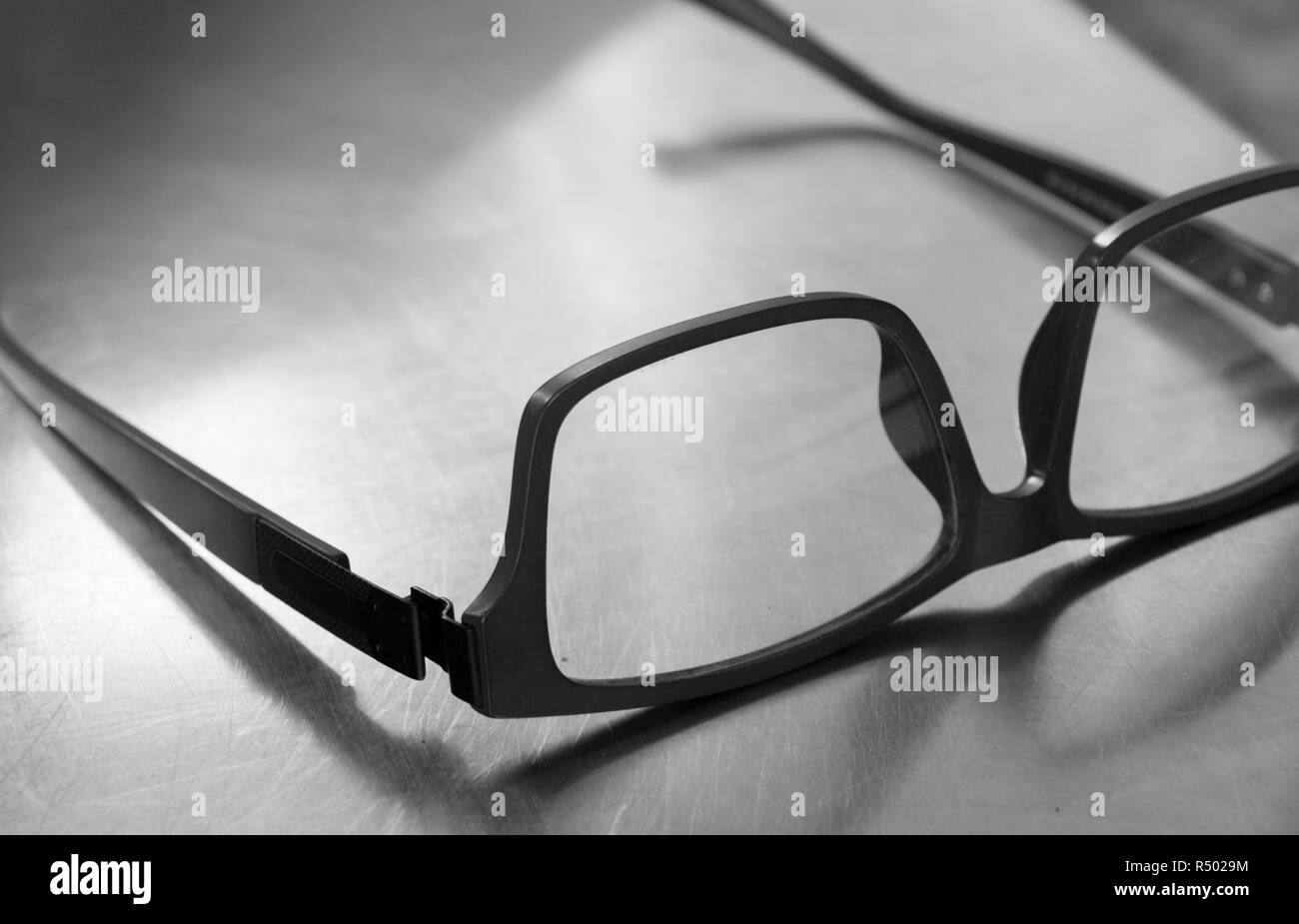 PLASTIC FRAME GLASSES ON STEEL TABLE Stock Photo Alamy