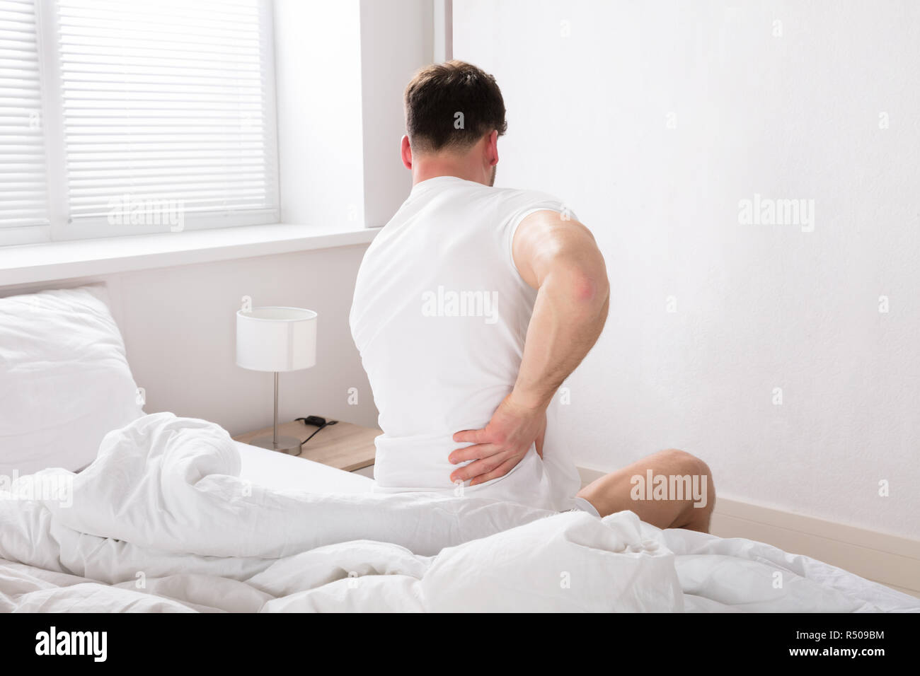 Man Sitting On Bed Having Back Pain Stock Photo Alamy