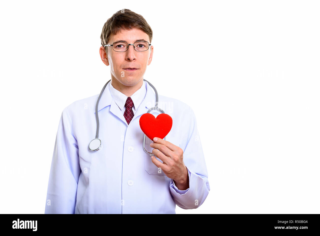 Studio shot of man doctor holding red heart  Stock Photo