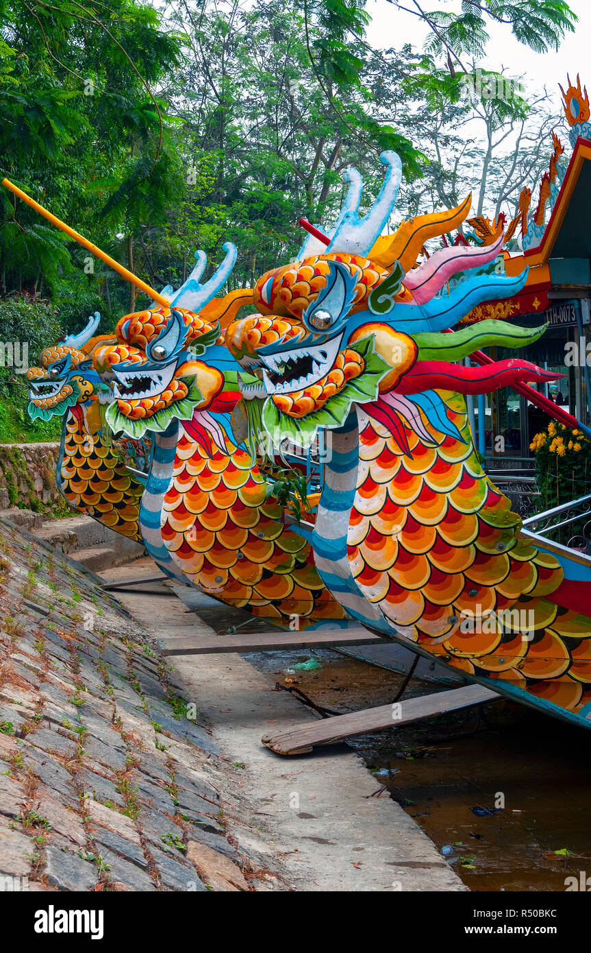 Dragon boats lined up and waiting for tourists outside the Thien Mu Pagoda on the Perfume River, Hue, Vietnam Stock Photo