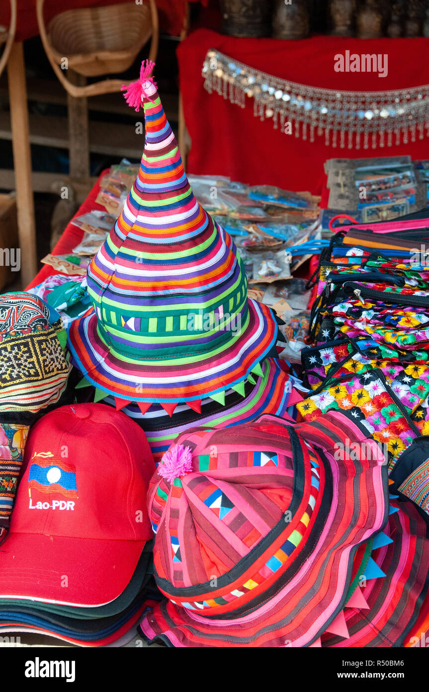 A selection of colourful local merchandise, hats,scarves,bags, and souvenirs for sale on market stall - Luang Prabang, Laos, Lao Stock Photo