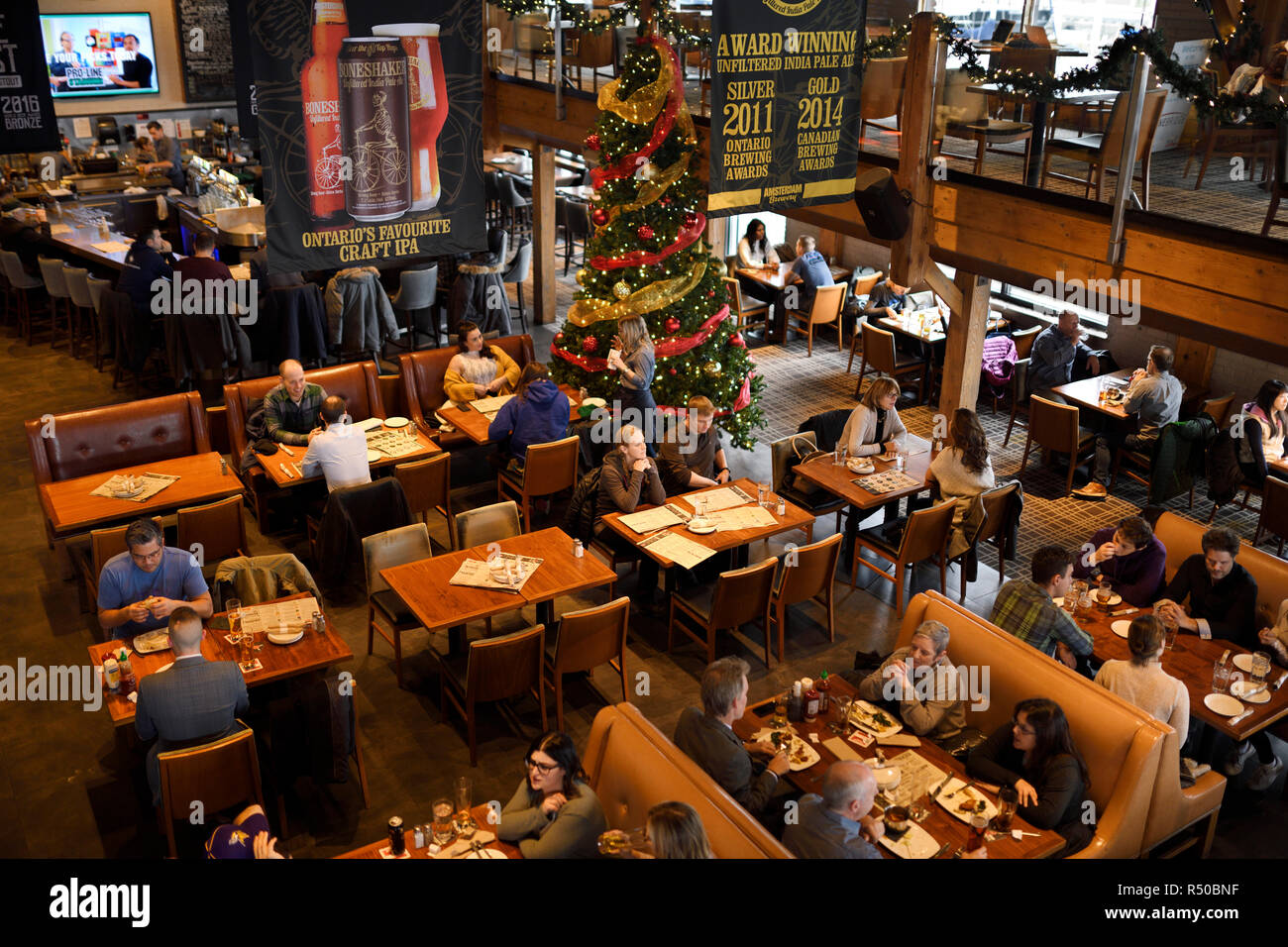 Customers at tables in restaurant bar and brewery of Amsterdam Brewhouse restaurant at Harbourfront Toronto Stock Photo