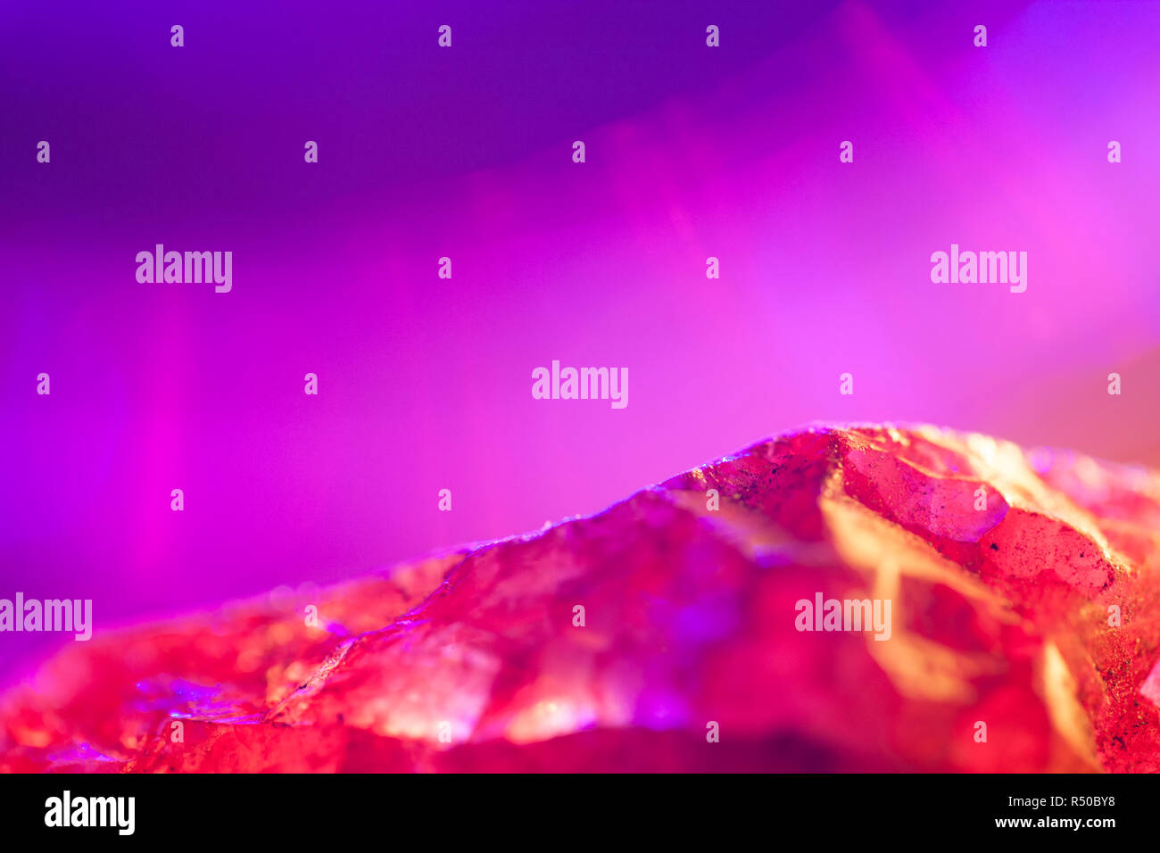 Pink Quartz crystal specimen shot using beautiful colourful lighting.Pink Gemstone.With copy space. Stock Photo
