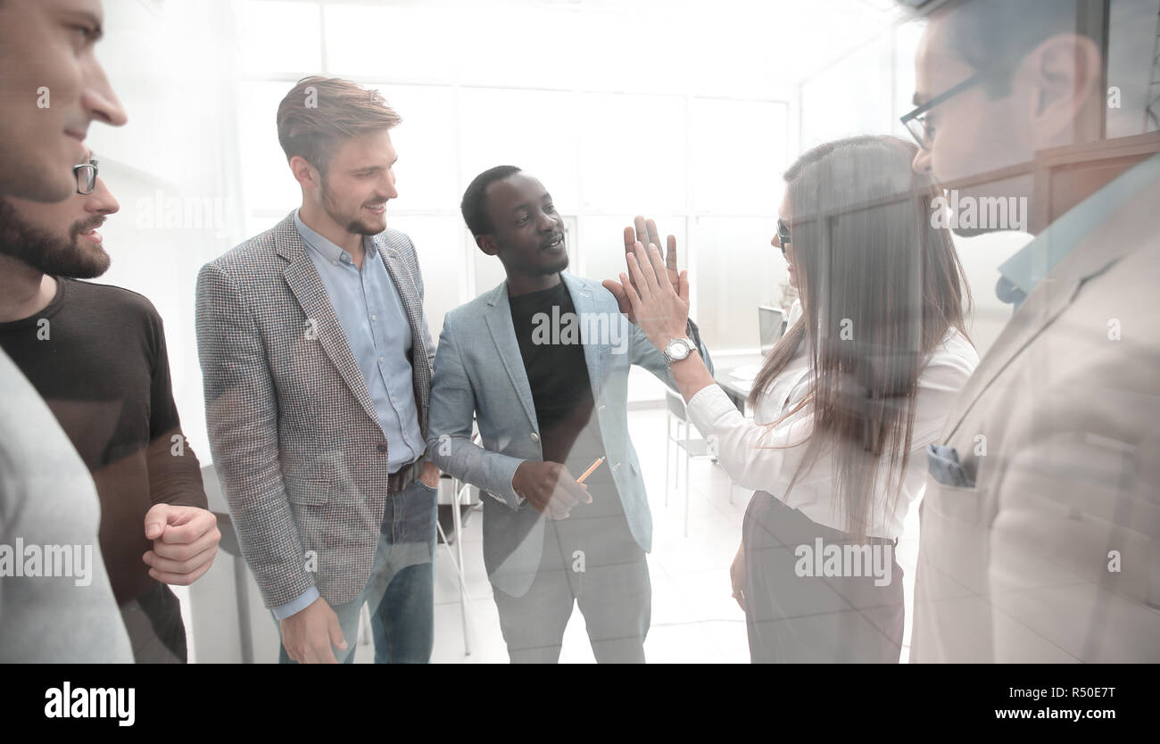 Group of young colleagues giving each other a high five Stock Photo - Alamy