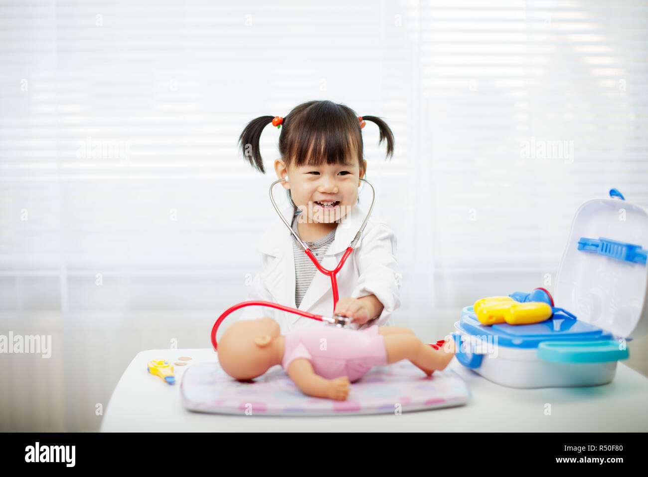 Toddler baby girl pretend playing as doctor at home Stock Photo - Alamy