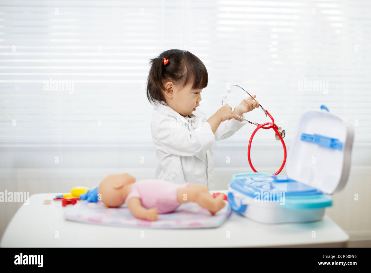 Toddler baby girl pretend playing as doctor at home Stock Photo - Alamy