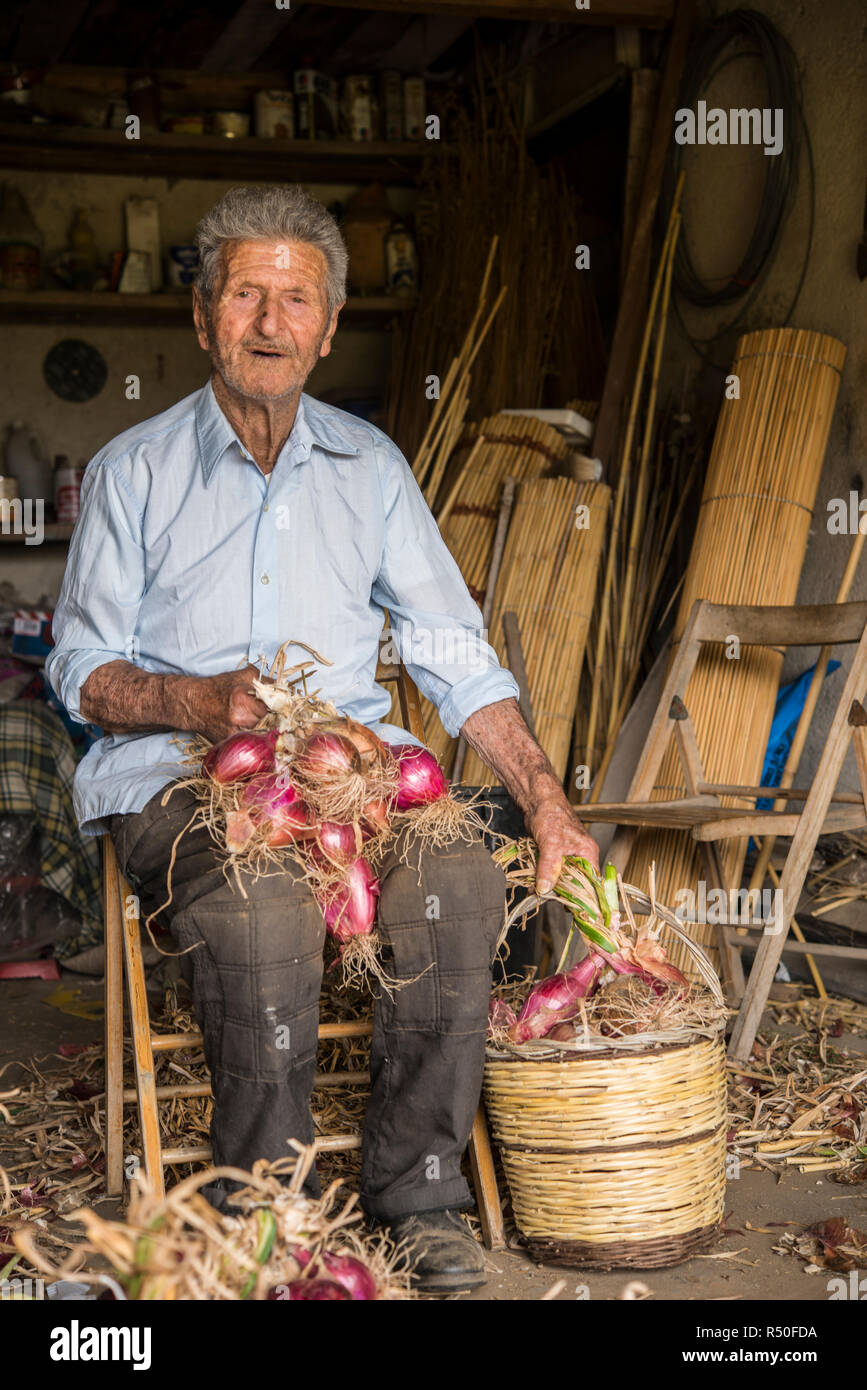 Pantelleria, Sicily, Italy, june 2018, the island's peasant binds the onions with the braid technique Stock Photo