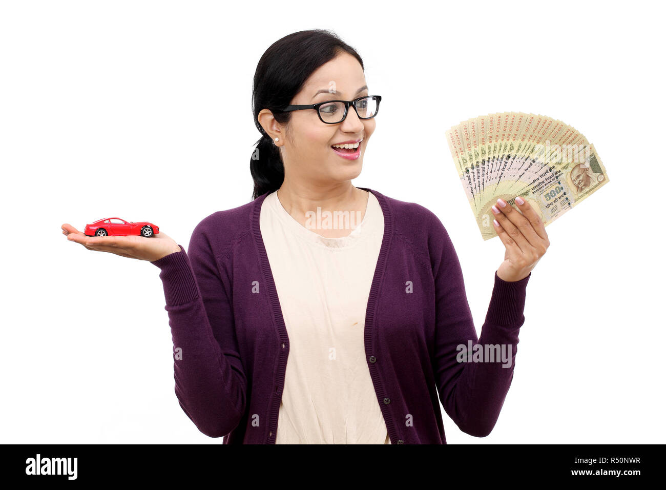 Young woman holding a toy car and Indian rupee notes Stock Photo