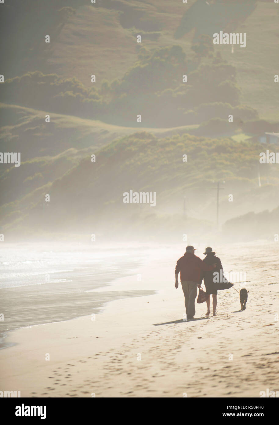 Couple walking their dog on the beach, the great ocean road, australia Stock Photo