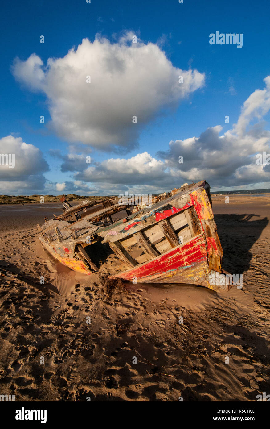 old wooden shipwreck on beach with blue sky clouds Stock Photo - Alamy