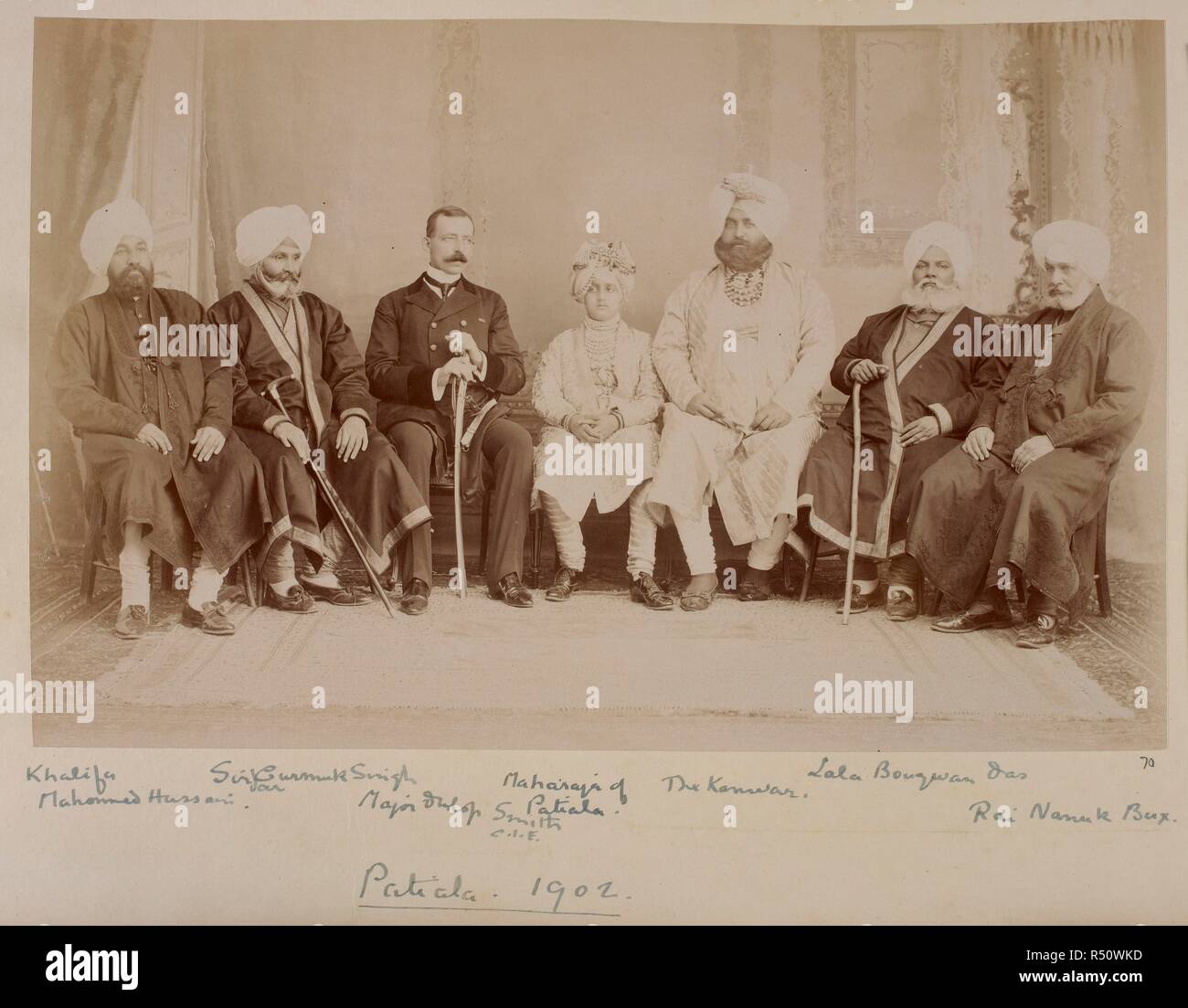 Photograph of the Maharaja of Patiala with J.R. Dunlop Smith and state officials, Patiala, 1902. Sitters are named, from left: 'Khalifa Mahomed Hussain; Sirdar Gurmuk Singh; Major Dunlop Smith, CIE; Maharaja of Patiala; The Kanwar; Lala Bougwan Das; Rai Nanuk Bux'. Portrait of the Maharaja of Patiala with J.R. Dunlop Smith and state officials, Patiala, 1902. India; Patiala; Punjab; Punjab (India); Nov 1902. Source: Photo 355/2/(70). Stock Photo