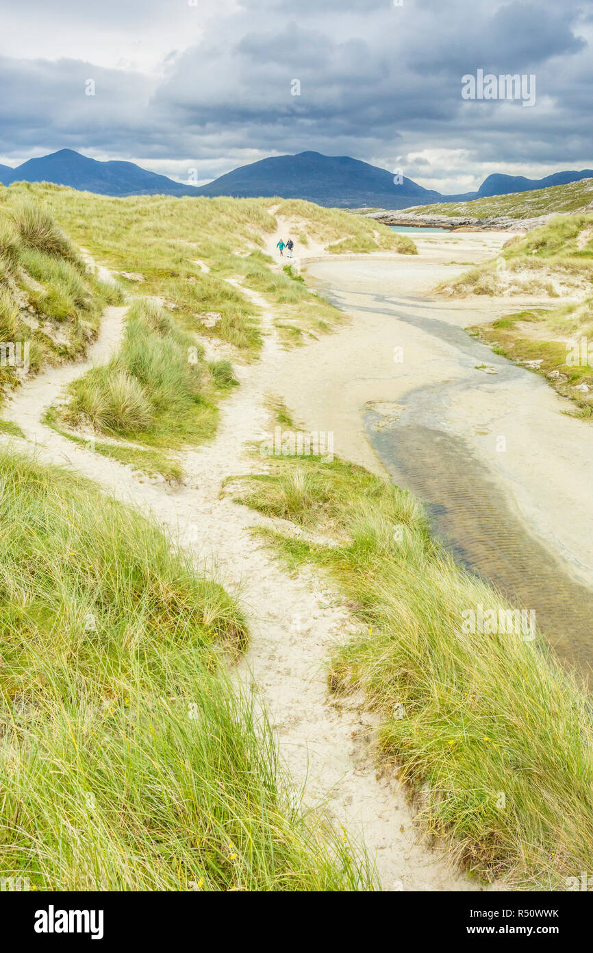 A couple walking along a path leading to Luskentyre Beach, Isle of Harris, Outer Hebrides, Scotland, UK Stock Photo