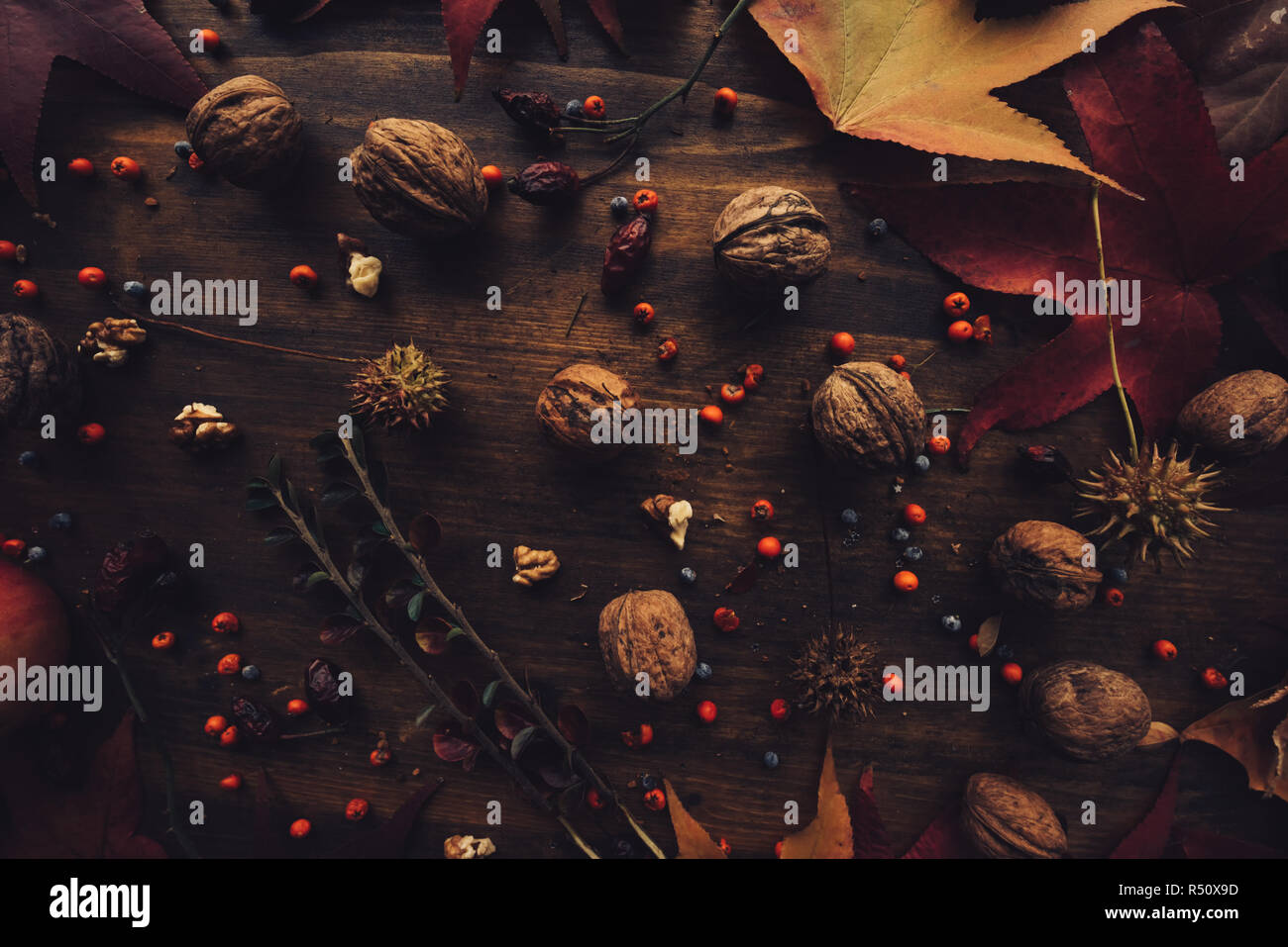 Rustic top view flat lay autumn arrangement decoration with some fruit and dry maple leaves on wooden table Stock Photo
