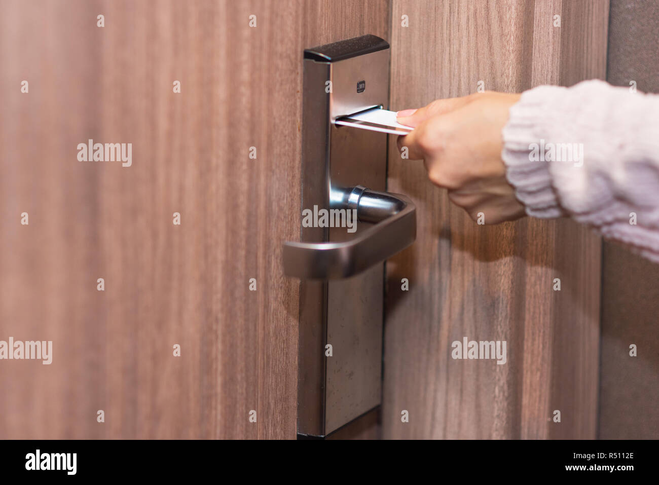 Woman hand inserting card to open electronic lock in hotel door Stock Photo