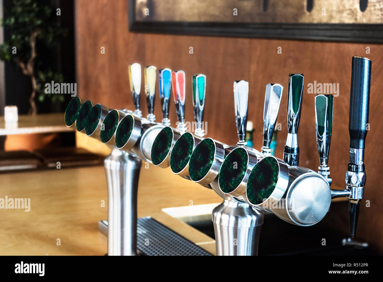 A row line of beer dispensers over a wooden wall background inside a