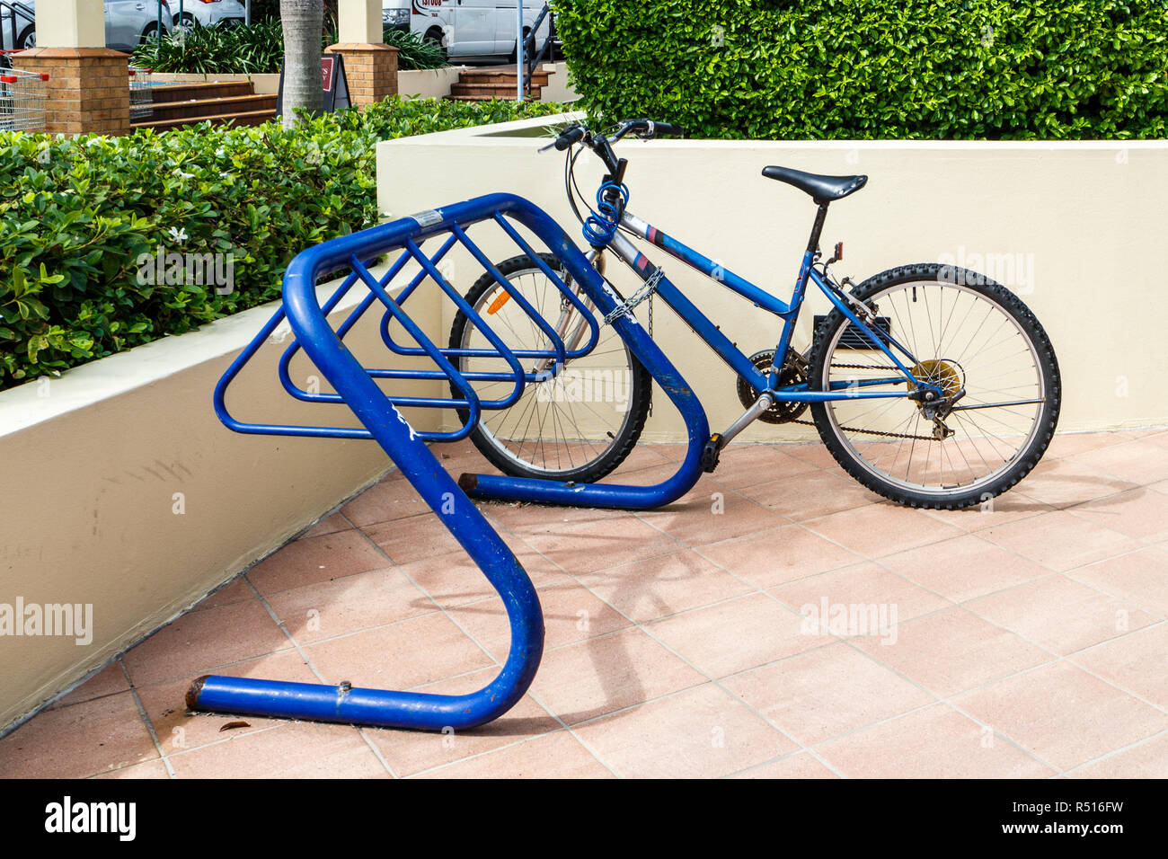 Blue bicycle parked in bicycle stand Stock Photo