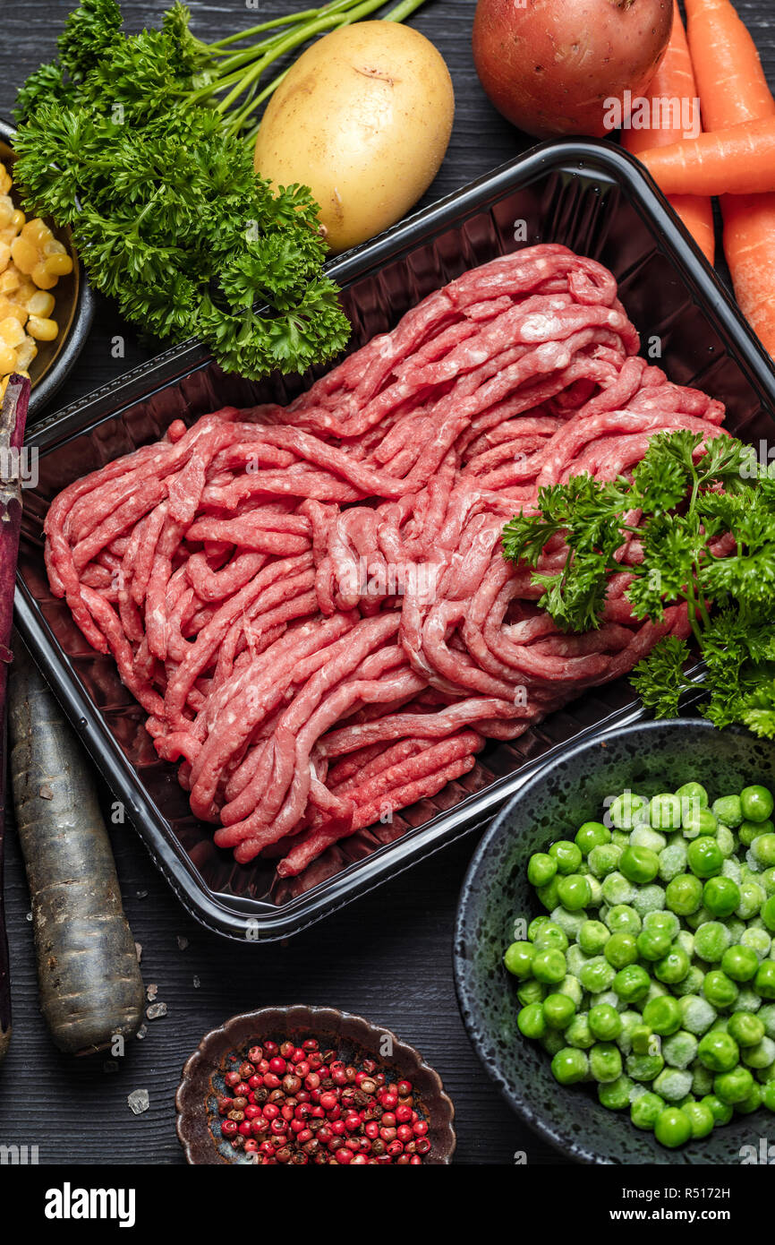 Raw minced meat in container with ingredients for shepherds pie with