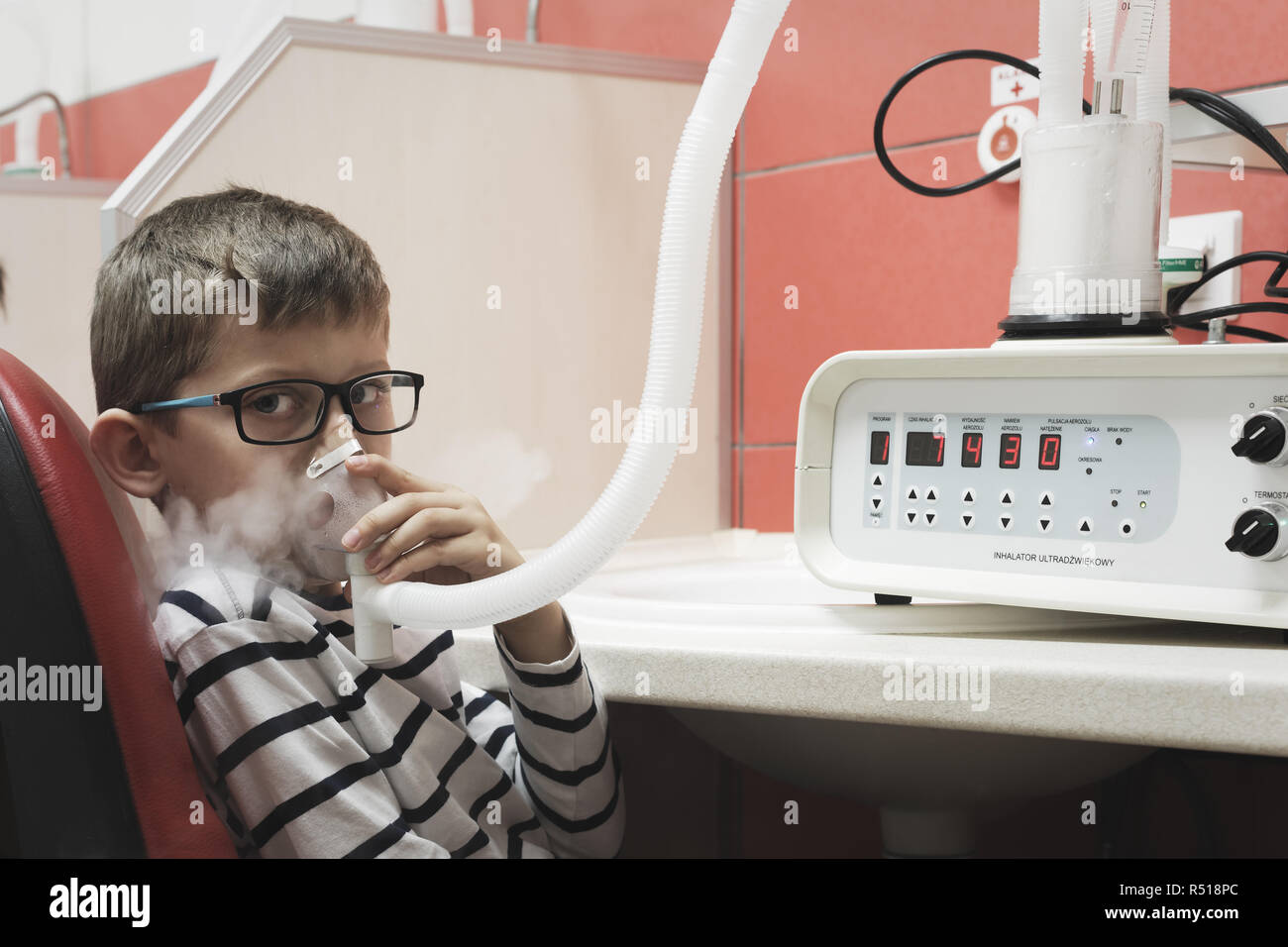 Young boy taking respiratory inhalation as asthma immuno therapy in clinic Stock Photo