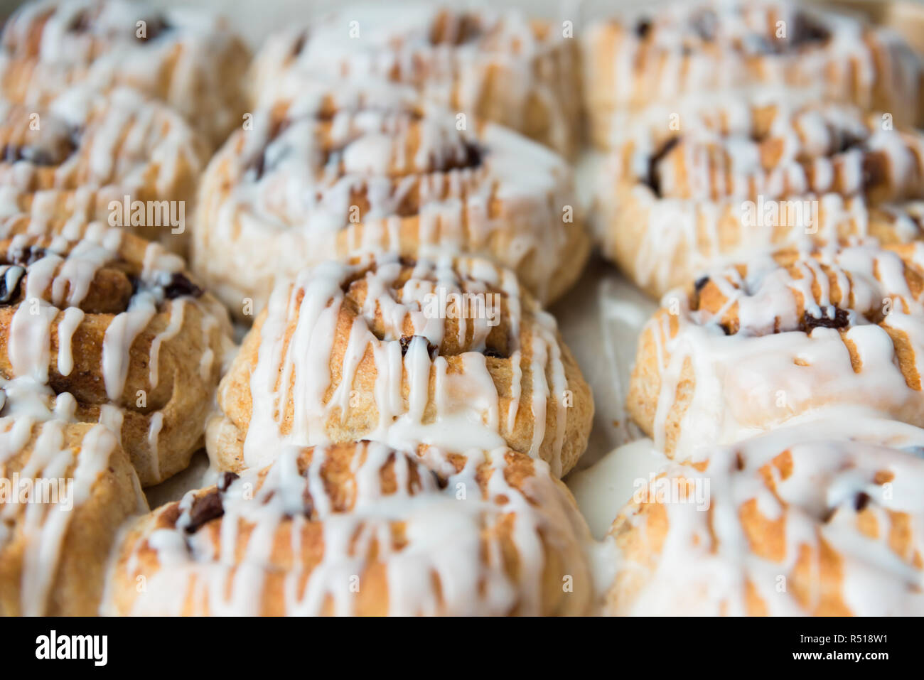 Full-frame freshly frosted cinnamon rolls in pan close-up Stock Photo
