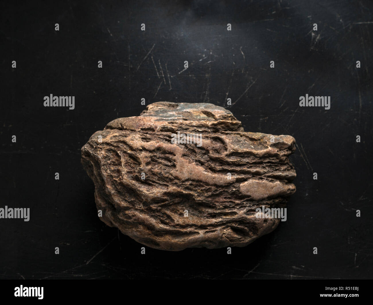 Weathered Rock On Dark Scratched Background. Legendary Artifact of Power, Courage and Healing Symbol Concept. Stock Photo